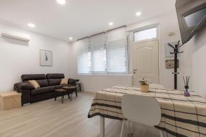 马德里4Torres Homes - Carmen的客厅配有桌子和沙发