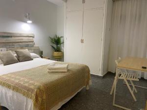 马贝拉Hostal Paco Marbella的一间卧室配有一张床、一张桌子和一张书桌