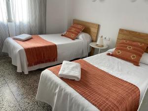 马贝拉Hostal Paco Marbella的酒店客房,配有两张带毛巾的床