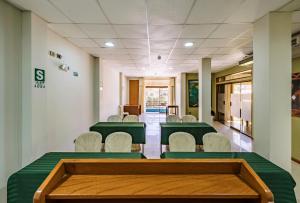 齐克拉约Hotel Casa de la Luna的一间会议室,配有绿色的桌椅