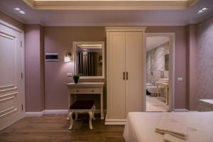 戈里察Legacy Boutique Hotel的一间卧室配有一张床、一个梳妆台和镜子