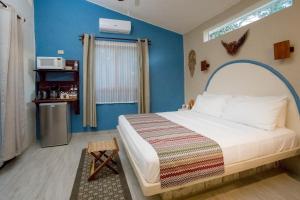 图卢姆ALDEA JO-YAH的一间卧室配有一张蓝色墙壁的床