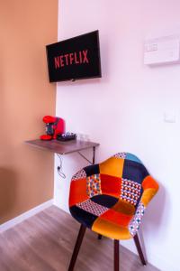 鲁贝NG SuiteHome - Lille I Roubaix Eurotéléport I Gambetta - Netflix & Wifi的一张五彩缤纷的椅子,坐在一张桌子上