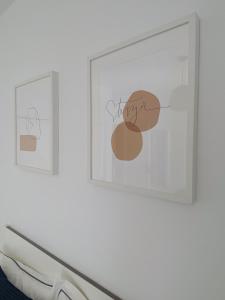科斯塔特吉塞Apartamentos Cataira的两幅画在一间房间里白色墙上