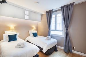 尚蒂伊Suite Appart Place Versepuy的带窗户的客房内的两张床