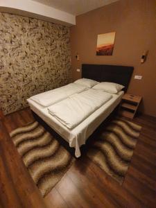 普里耶多尔Guest House Babilon的卧室内的一张大床,卧室内有地毯
