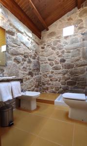希奥Casa Rural A Bouciña的带卫生间和水槽的石墙浴室