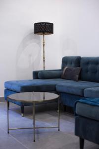 阿雅克修Bon'appart的客厅里设有一张蓝色的沙发和一张桌子