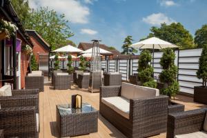 温彻斯特温彻斯特酒店的一个带柳条椅、桌子和遮阳伞的庭院