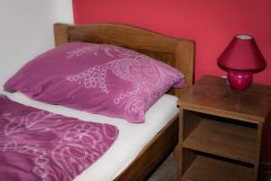 UdbinaGuesthouse Pink Panther的一张带粉红色枕头的床和床头灯
