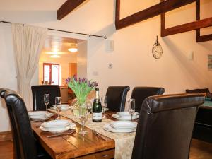 利斯卡德Kingfisher Barn的餐桌、椅子和一瓶葡萄酒