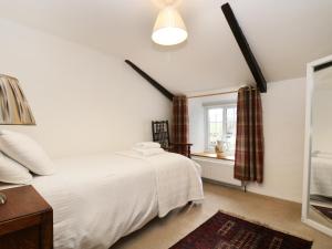洛斯特威希尔13 Castle Hill的卧室配有白色的床和窗户。