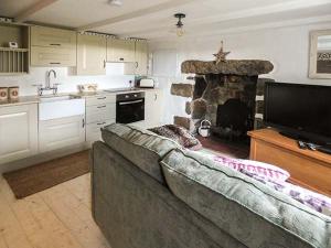 BugleLongview Cottage的带沙发和石制壁炉的客厅