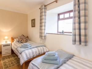 LongwittonRidge Cottage的一间卧室设有两张单人床和一个窗户。