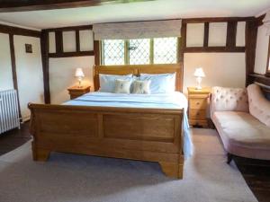 ChiddingstoneTudor Wing的一间卧室配有一张大型木床和一张沙发