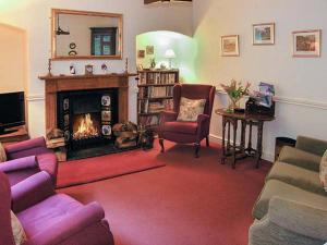 彻克Aqueduct Cottage的客厅设有壁炉和紫色椅子