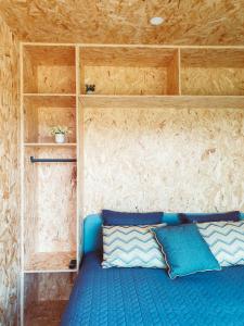TorneiroRefúgio do Valouto的小房间配有一张带蓝色枕头的床