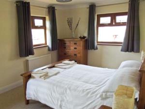 FalstoneHartam House的卧室配有白色的床和2条毛巾