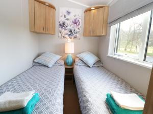 FassfernThe Four Oaks Chalet的小型客房设有两张单人床和窗户。