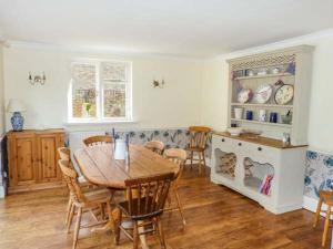 Holmbury Saint MaryWoodhill Cottage的一间带木桌和椅子的用餐室