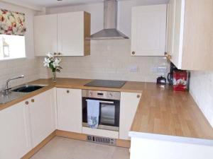 WortleyHollins Wood Bothy的厨房配有白色橱柜和台面
