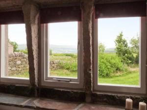 MytholmroydKnowle Lodge的客房内的3扇窗户享有田野景致