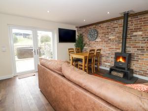 LlangyninFfynnonlwyd Cottage的带沙发和壁炉的客厅