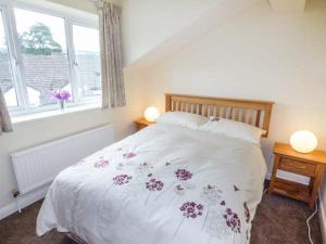 HorrabridgeMoorside的卧室配有带鲜花的白色床