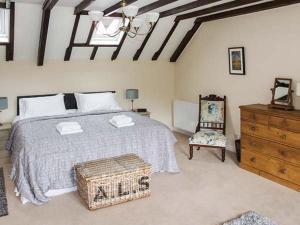 惠特彻奇Ganarew Cottage的一间卧室配有一张床、一把椅子和一个梳妆台