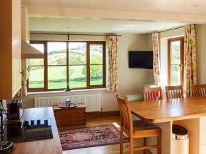 PontnewyddGlebe Farm Cottage的客厅设有餐桌和大窗户