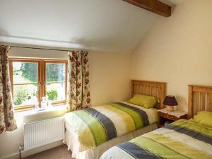 PontnewyddGlebe Farm Cottage的一间卧室设有两张床和窗户。