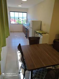 埃斯特城Apart 2 habitaciones vista a Itaipú - 32的厨房配有木桌和桌椅