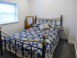 Chelmorton2 Primitive Croft的一间卧室配有一张带蓝色和白色棉被的床