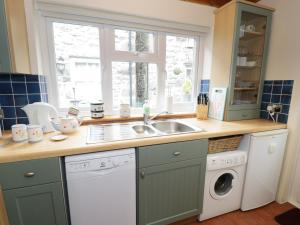 多尔盖罗Cae Tanws Bach的厨房配有水槽和洗衣机
