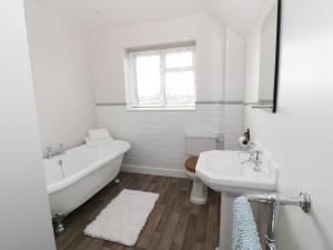 布罗德韦Glencoe Cottage的白色的浴室设有浴缸和水槽。