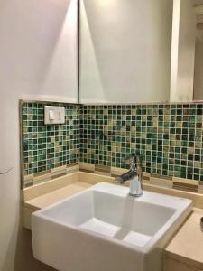 埃斯特角城Apartamento Edificio Unique, Punta del Este的浴室铺有绿色瓷砖,配有白色水槽。