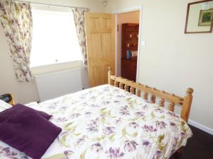 Severn StokeThe Packing House的一间卧室配有一张带花卉床罩的床