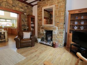 WolsinghamWhitfield Cottage 21 Silver Street的客厅设有砖砌壁炉和椅子