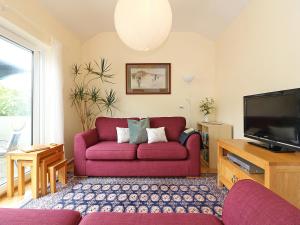 圣贾斯特Parula的客厅配有红色沙发和电视