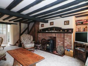 ClenchwartonMrs Dale's Cottage的客厅设有壁炉和电视。
