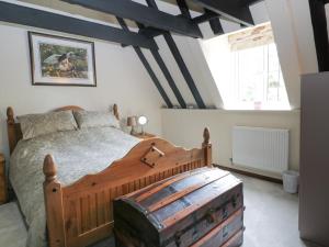 ClenchwartonMrs Dale's Cottage的一间卧室设有一张木床和一个大窗户。
