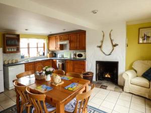 HicklingKingsley Cottage的厨房配有桌椅和壁炉。