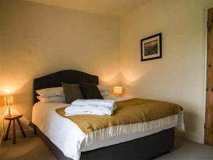 伊尔克利Beacon Cottage的一间卧室配有带白色床单和枕头的床。