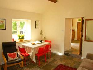 莫尔德Stone Cottage的一间带桌子和红色椅子的用餐室