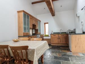 阿伯加文尼Longside的厨房配有桌子、一些椅子、桌子和柜台。