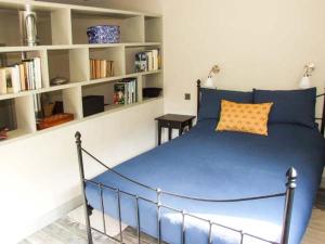 瓦伊河畔罗斯The Stable的一间卧室配有蓝色的床和书架