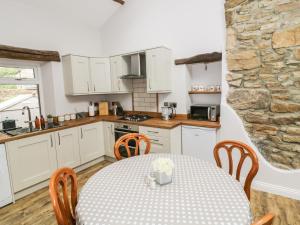 格拉辛顿Rose Cottage的厨房以及带桌椅的用餐室。