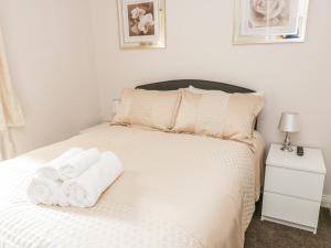 格拉辛顿Rose Cottage的卧室配有白色床和毛巾