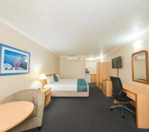 格拉德斯通Harbour Sails Motor Inn的配有一张床和一张书桌的酒店客房
