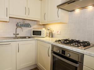 惠特比Platform 12的厨房配有白色橱柜和炉灶烤箱。